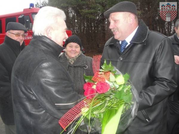 : Prezes Krzysztof Kołodziejczyk odbiera kwiaty od sołtysa Włodzimierza Skrzypiciela. 